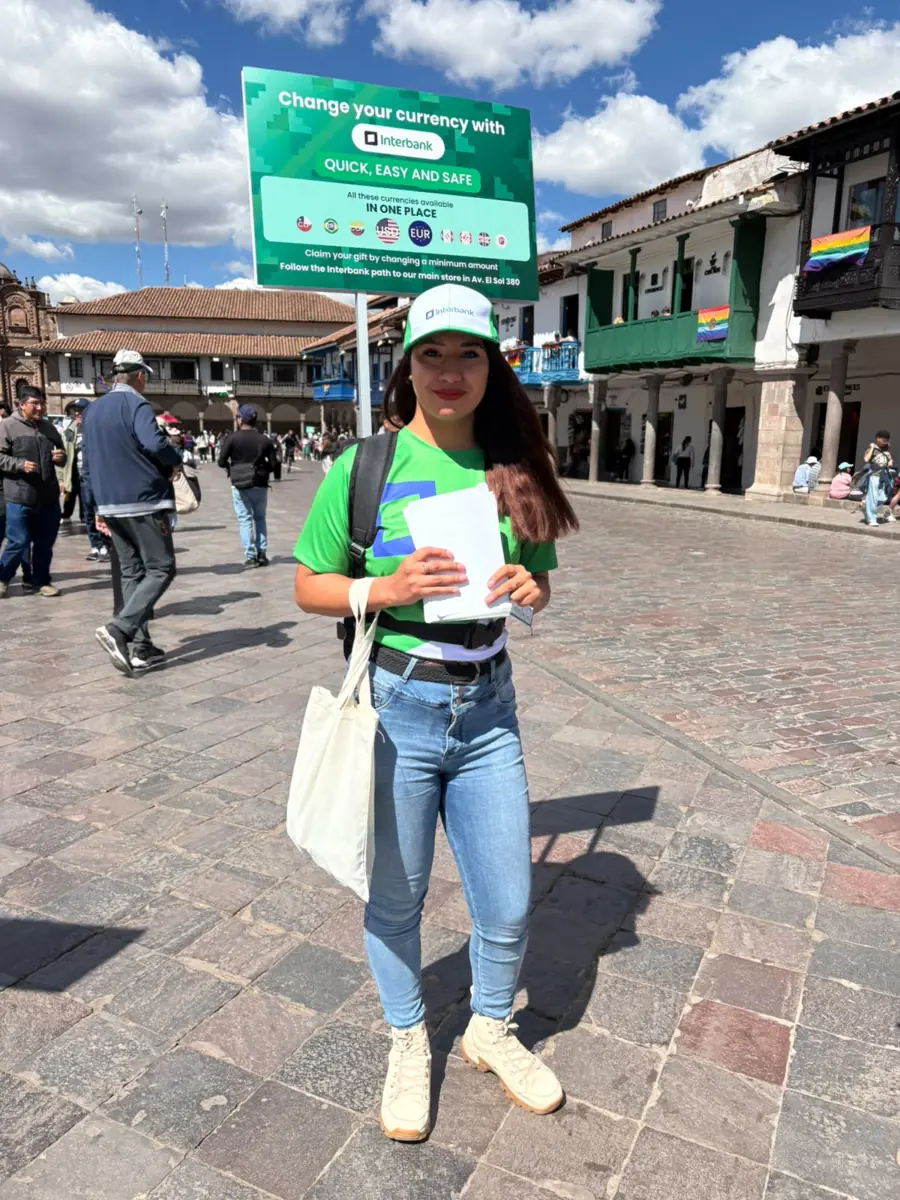 Promotora de Interbank con camiseta, gorra y bolsa promocional en Cusco