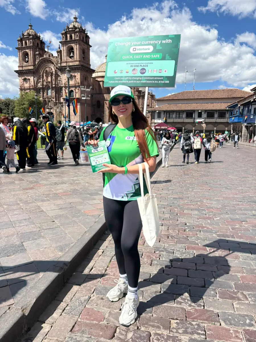 Promotora de Interbank frente a la Catedral del Cusco con merchandising personalizado